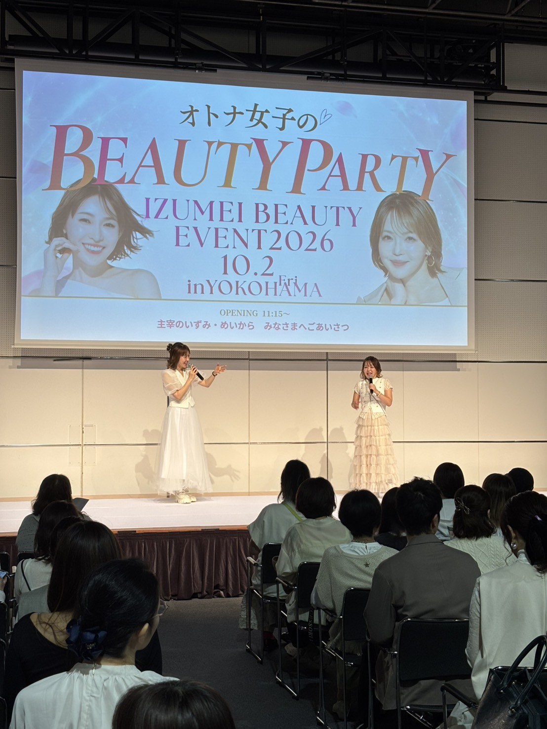 【イベントレポート】美容家&人気ブランドが横浜に大集合!「オトナ女子のBEAUTY PARTY」14ブース×ステージ×福引で“会える・試せる・キレイになれる”一日 2 ステージ上で来場者に挨拶する主宰の二人。スクリーンにはBEAUTY PARTYのメインビジュアルとオープニングの案内が映る