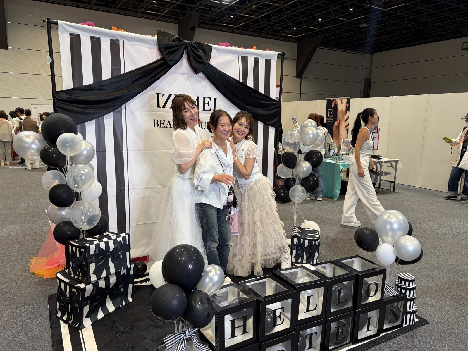 【イベントレポート】美容家&人気ブランドが横浜に大集合!「オトナ女子のBEAUTY PARTY」14ブース×ステージ×福引で“会える・試せる・キレイになれる”一日 4 黒いリボンとストライプが特徴のフォトブース。来場者が記念撮影をしている